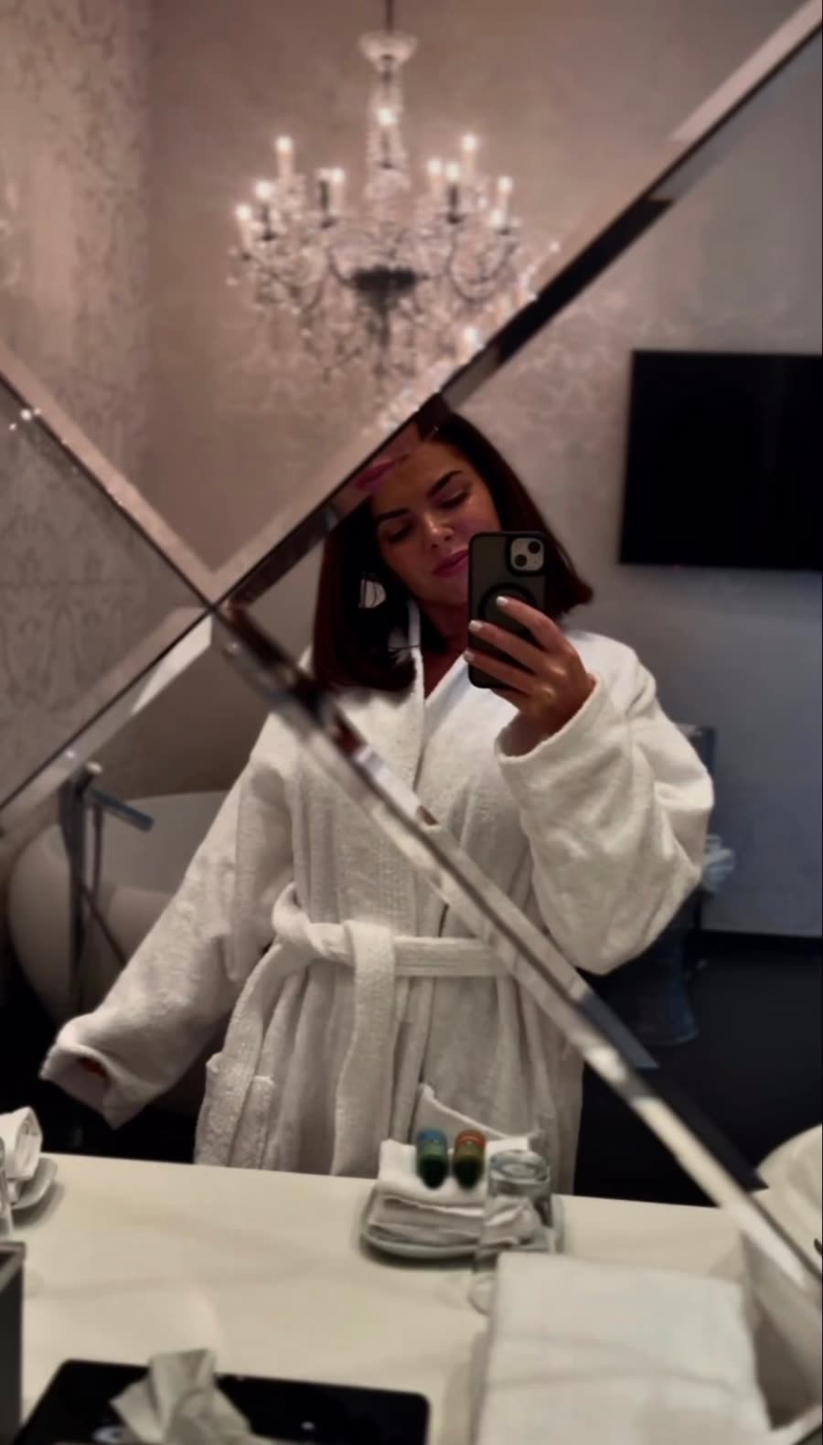 Mariane im Bademantel vor dem Hotelspiegel